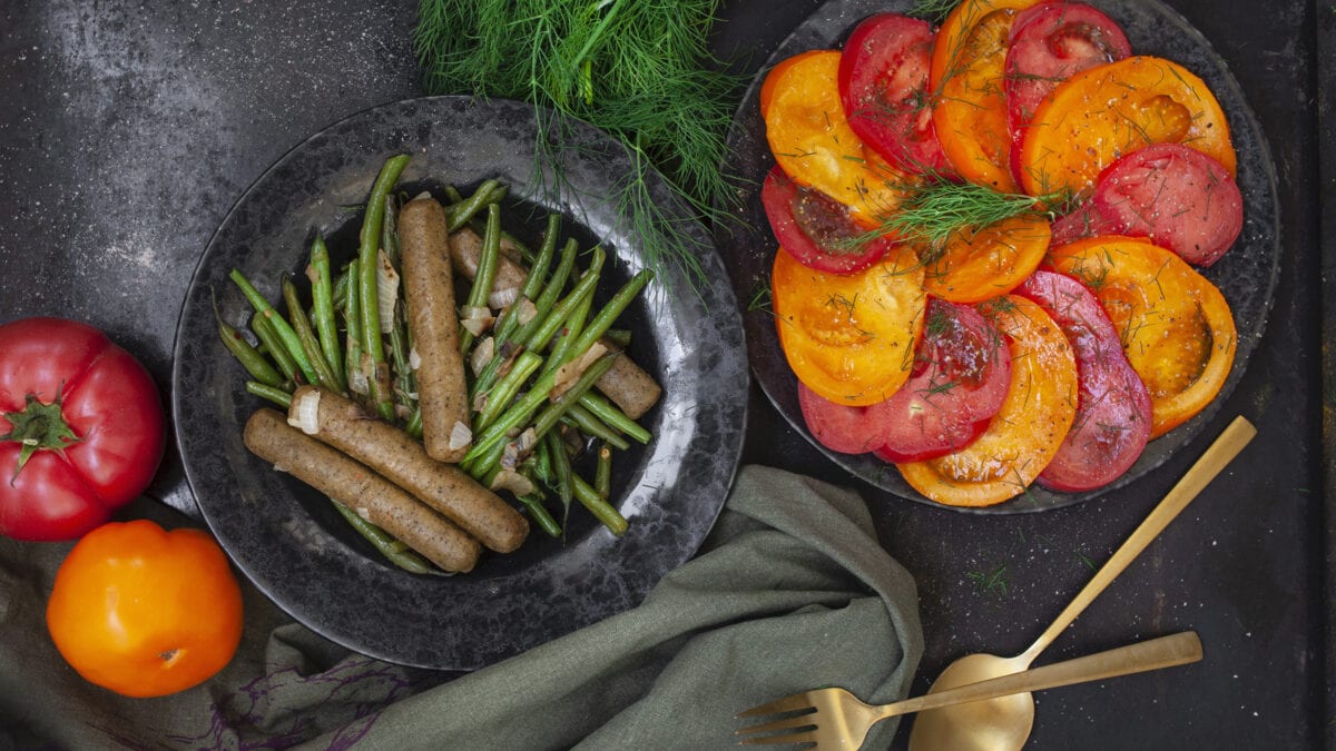 Sommerlig ret med oksepølser, bønner og frisk tomatsalat